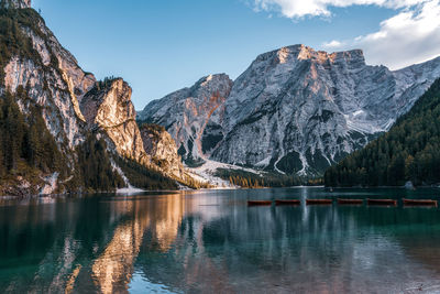 Scenic view of lake by snowcapped mountains against sky