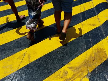 Low section of people walking on zebra crossing