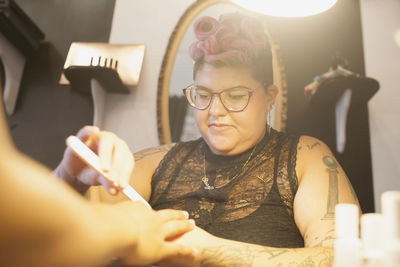 A beautician giving someone a manicure.