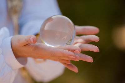 Close-up of hand holding crystal ball