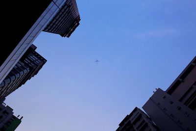 Low angle view of airplane flying against clear blue sky