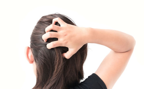 Rear view of woman with hand against white background