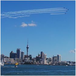 View of sea and cityscape against sky