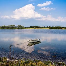 Fishing boat in lake against sky