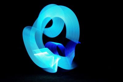 Close-up of illuminated lighting equipment against black background