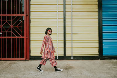 Full length of woman standing against wall