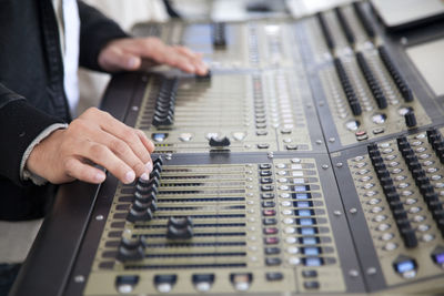 Technician adjusting sound mixers at studio