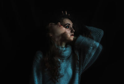 Multiple exposure of woman against black background