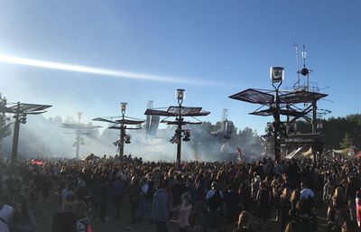 Crowd at music concert against sky