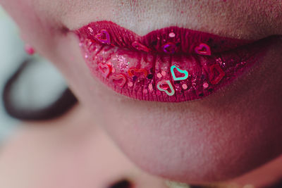 Close-up of woman wearing lipstick with decorations