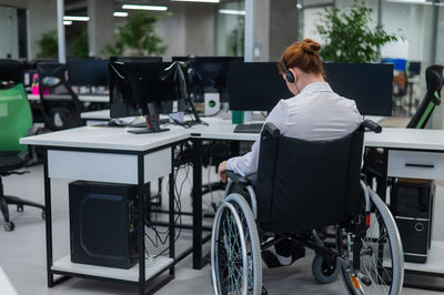 Rear view of woman sitting on wheelchair