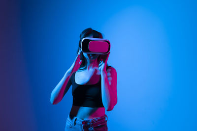 Rear view of woman standing against blue background