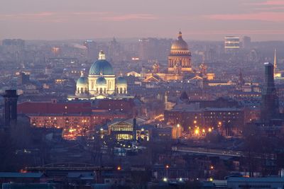 High angle view of city lit up against sky