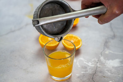 Close-up of hand pouring drink in glass