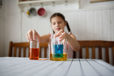 Cute girl playing with liquid in jar