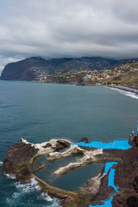 Scenic view of sea and mountains against sky