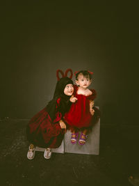 Two beautiful little girls wearing maroon dresses