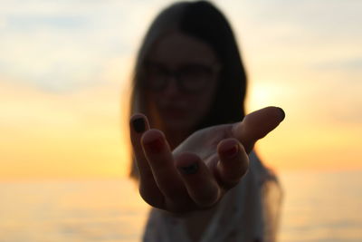 Portrait of young woman against sky during sunset