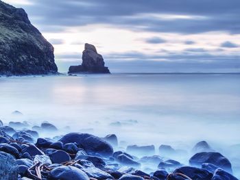 Rocks in sea against sky