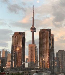 Modern buildings in city against sky during sunset