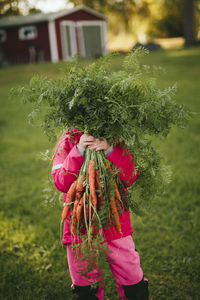 Girl holding bunch of carrots