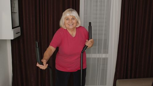Portrait of smiling woman exercising at home