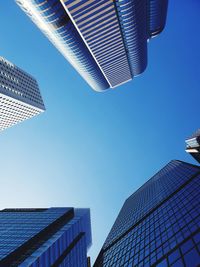 Low angle view of modern buildings against clear blue sky