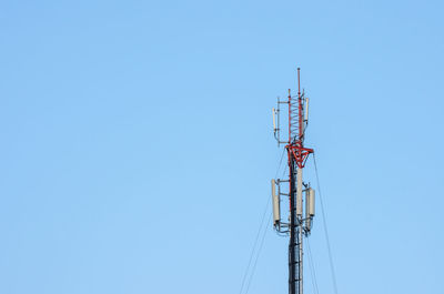 Low angle view of communications tower against blue sky