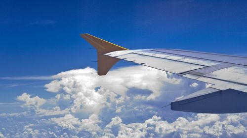 Cropped image of airplane flying over clouds