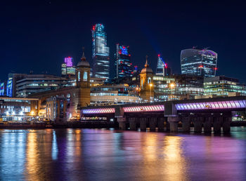 Skyline of london at night  illuminated bridge over thames river and city of london 