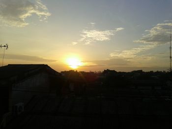 Silhouette buildings against sky during sunset