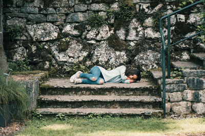 Full length of woman lying down on staircase