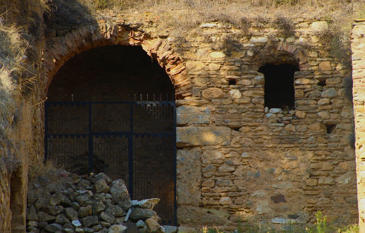 STONE WALL WITH OLD BUILDING