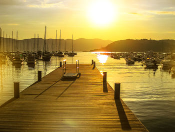 Boats moored in sea at sunset