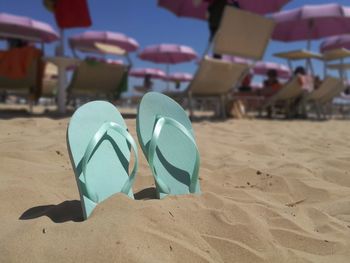 Close-up of shoes on beach