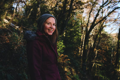 Portrait of smiling woman standing in forest