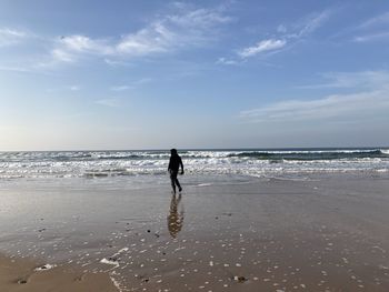 Rear view of man walking on beach