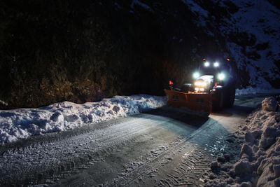 Illuminated snow covered land at night