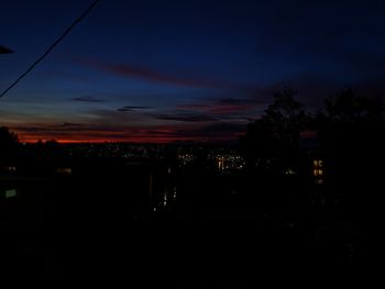 Silhouette buildings against sky at night