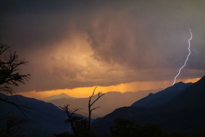 Silhouette of mountain against dramatic sky during sunset