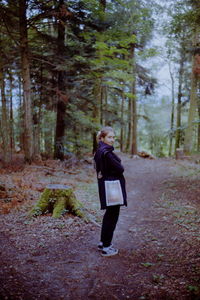 Woman walking on footpath in forest