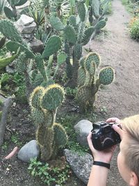 Midsection of person photographing cactus