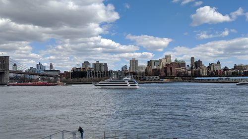 Scenic view of river by buildings against sky