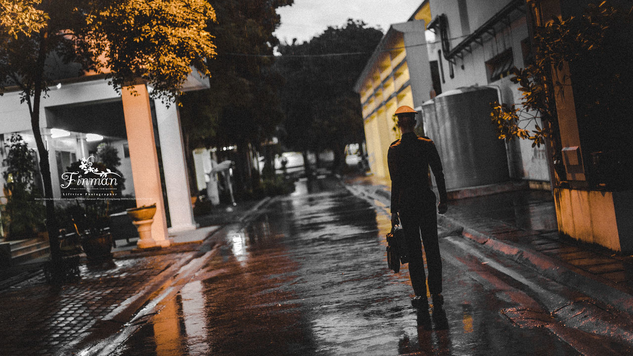 REAR VIEW OF WET WALKING ON STREET DURING RAIN