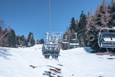 Skiers enjoying on ski lift over snowy mountain landscape