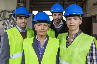 Team of manual workers in protective workwear at factory