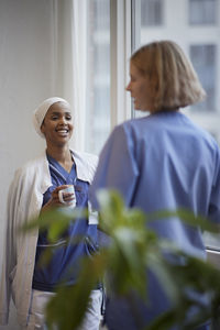 Female doctors standing and talking at hospital corridor