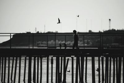 Silhouette man with arms outstretched against sky during sunset