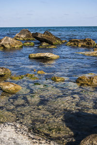 Scenic view of rocks in sea against sky