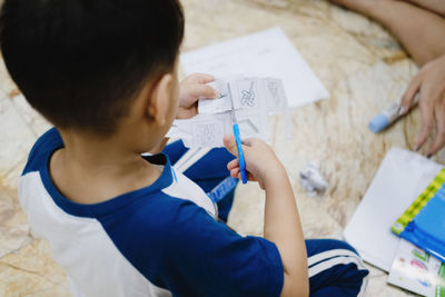 High angle view of boy doing craft